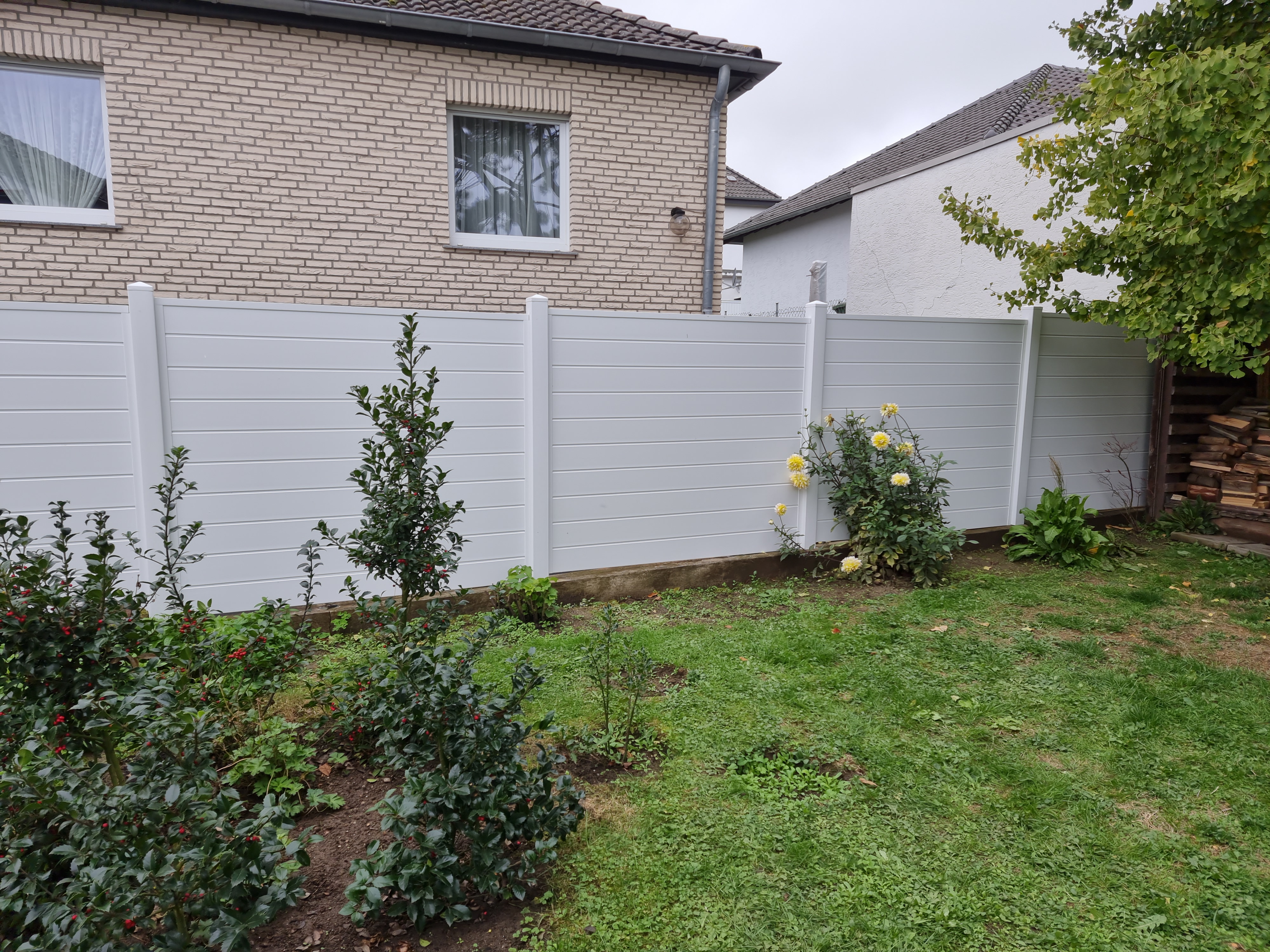 Grundstückseinfriedung mit Zaun und Hecke